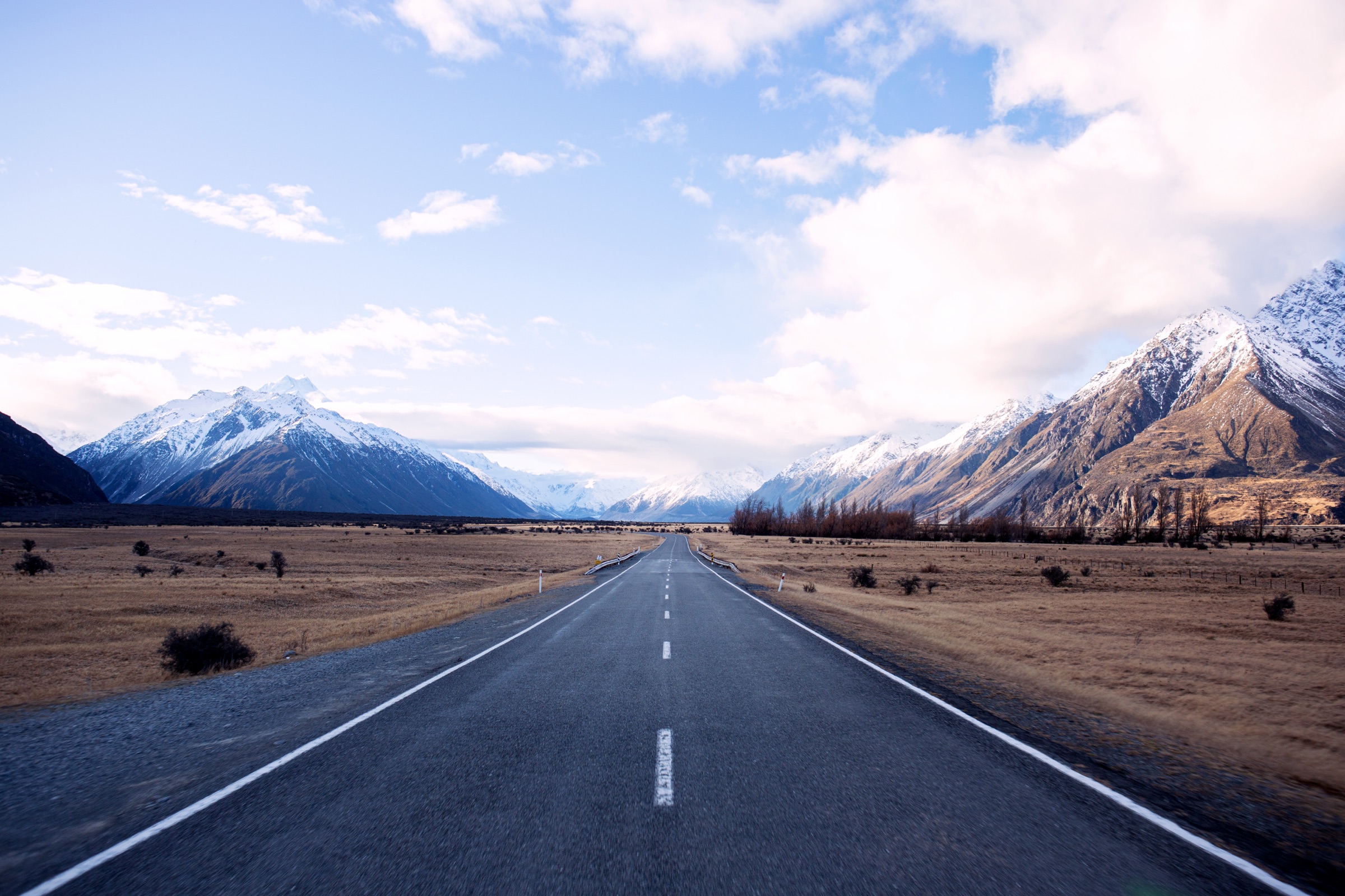 An open road running through a wide mountain valley, New Zealand's South Island