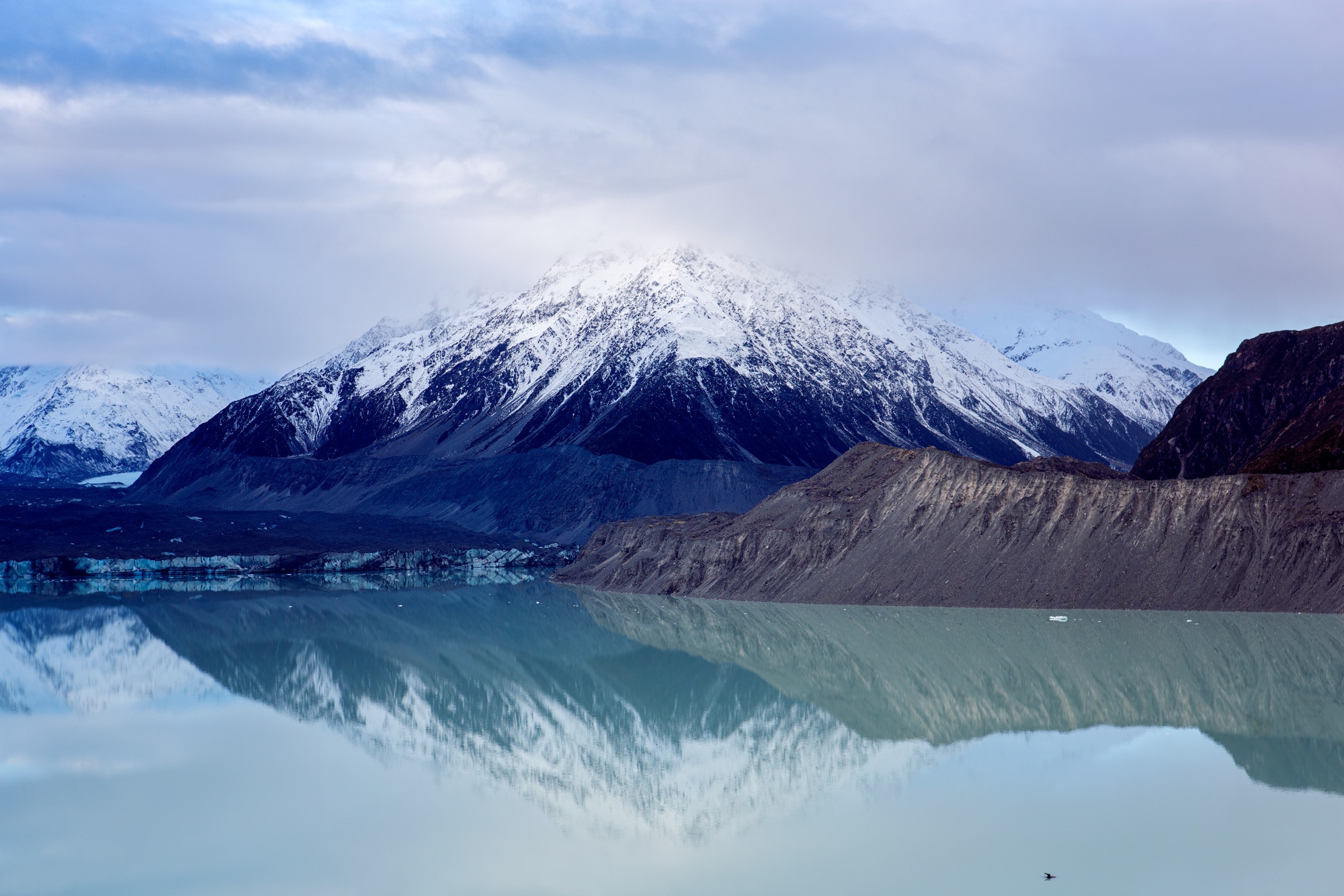 Snow-dusted mountains above a wide braided river valley, New Zealand
